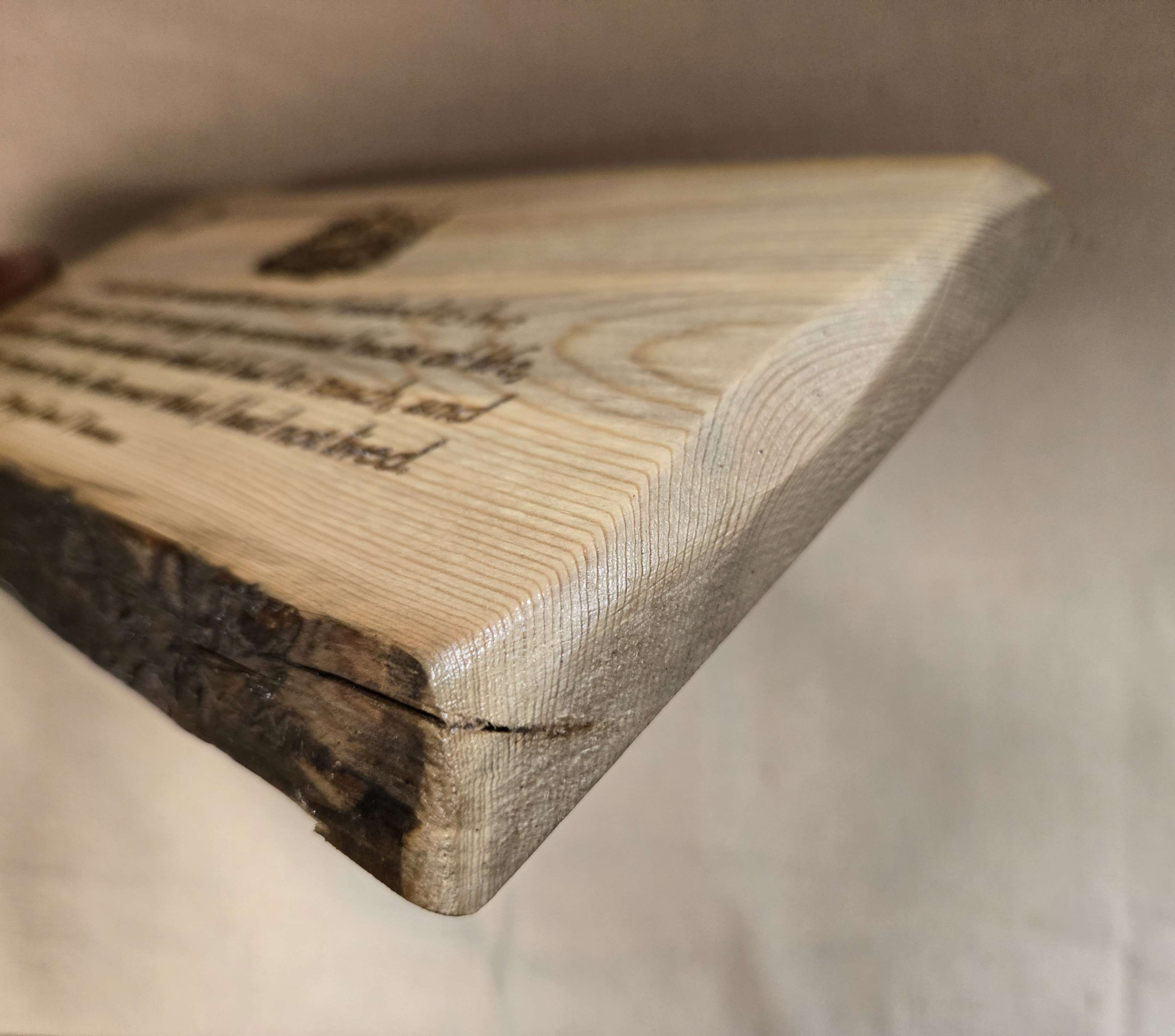 Wooden block with engraved text on a white background